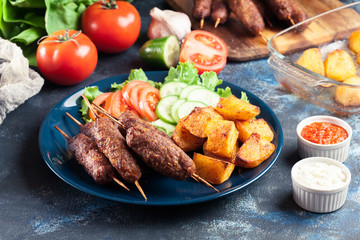 Grilled shish kebab served with fried potatoes