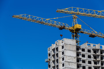 Lots of tower construction site with cranes and building with blue sky background