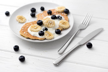 Sweet oatmeal pancakes with cream, blueberry and banana. Healthy Breakfast concept.