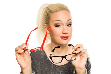 portrait of beautiful young blonde compare two pairs of glasses on white background