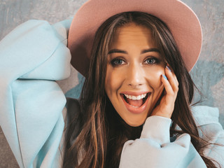 Young beautiful surprised woman looking at camera with hands near mouth. Trendy girl in casual...
