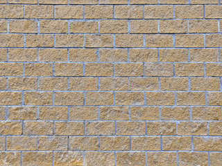 Wall background of light brown brick. The rough masonry of sand stone. Brick texture of sandy color limestone.