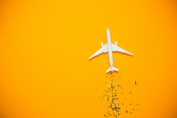 Toy airplane with sparkles on yellow background. Journey