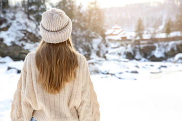 Beautiful woman at snowy resort, back view