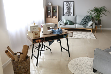 Sewing machine with accessories on tailor's workplace in atelier