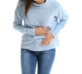 Young woman suffering from abdominal pain on white background