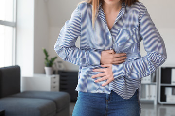 Woman suffering from stomachache at home