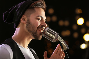 Handsome male singer with microphone on stage