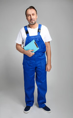 Portrait of handsome mature worker on grey background