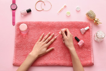 Woman doing manicure on color background