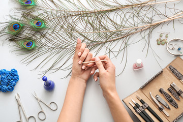 Woman doing manicure on light background