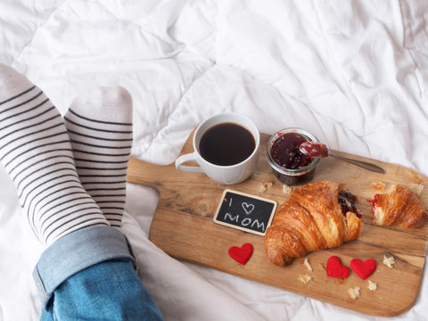 Muttertagsbrunch im Bett mit Kaffee und Croissant