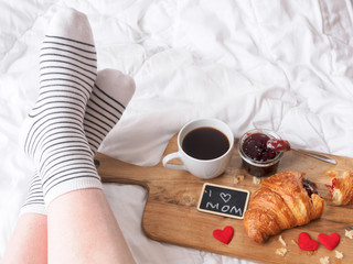 Frau mit Frühstück auf einem Serviertablett im Bett, Muttertagsbrunch, Kaffee