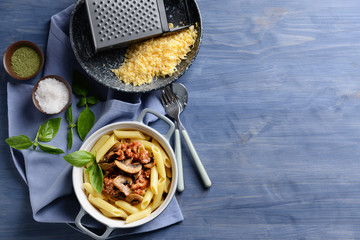 Pot with tasty boiled pasta on color wooden table