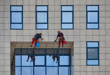 Novi Sad, Serbia, May 17th 2015. - Window cleaners working on building , cleaning the facade