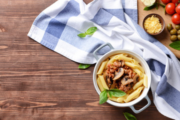 Pot with tasty boiled pasta on wooden table
