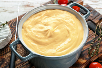 Cheese fondue on wooden board