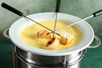 Cheese fondue with croutons on table