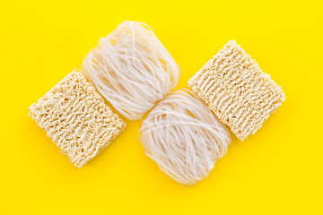 Rice vermicelli, noodles to cook Chinese and Japanese food design on yellow background top view copy space