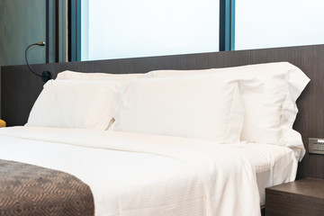 Beautiful luxury comfortable white pillow and blanket on bed with light lamp