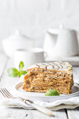 Traditional Hungarian Esterhazy piece of cake on a white wooden background.