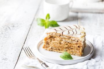 Traditional Hungarian Esterhazy piece of cake on a white wooden background.