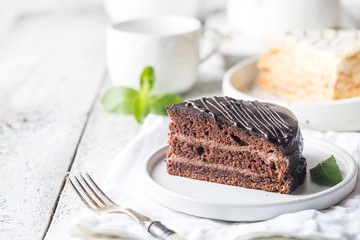 Delicious chocolate Prague cake on plate over white background