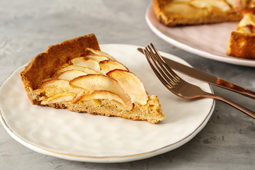 Plate with piece of tasty apple pie on table