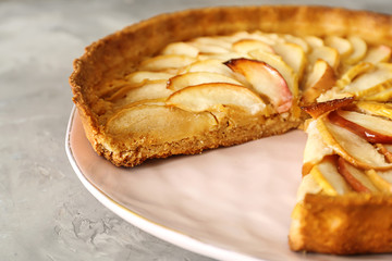Plate with tasty apple pie on table, closeup