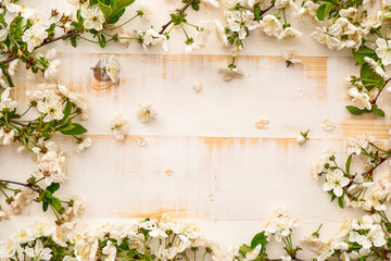 Frame made of beautiful blooming branches on light wooden background