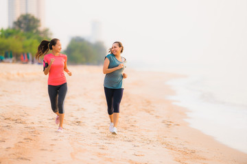 Portrait beautiful young sport asian woman running and exercise on the beach near sea and ocean at sunrise or sunset time