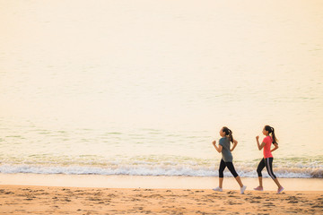 Portrait beautiful young sport asian woman running and exercise on the beach near sea and ocean at sunrise or sunset time