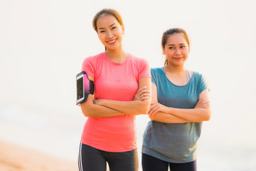 Portrait beautiful young sport asian woman running and exercise on the beach near sea and ocean at sunrise or sunset time