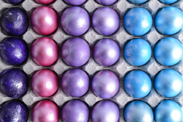 Beautiful Easter eggs in cardboard box, top view