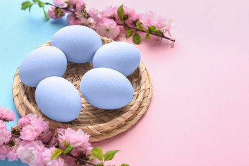 Beautiful Easter eggs with flowers on color background