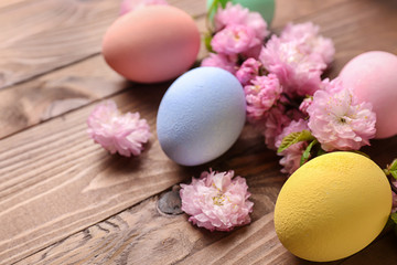 Fototapeta na wymiar Beautiful Easter eggs with flowers on wooden background