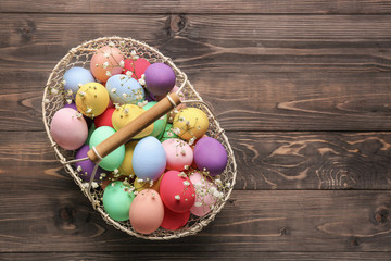 Obraz na płótnie Canvas Basket with beautiful Easter eggs on wooden background