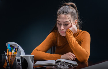 Young beautiful but stressed student girl studying for hard exam