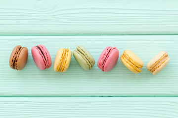 Macarons design on mint green wooden background top view space for text