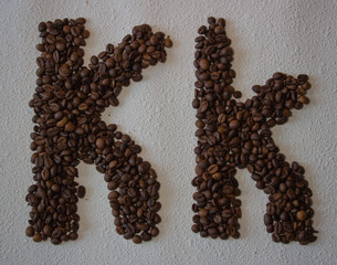 Image of roasted coffee beans shaped alphabet on a white background