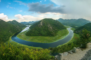 Beautiful mountain landscape with winding river, green forest, thunderstorm and cumulus clouds, top view, Montenegro