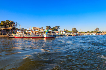 Fototapeta na wymiar Tourist boats moored near the shore of Nile river in Luxor, Egypt