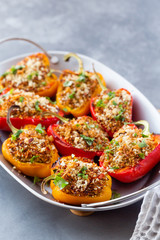 Vegetarian dish with peppers stuffed with quinoa, onion and tomato, sprinkled with walnuts.