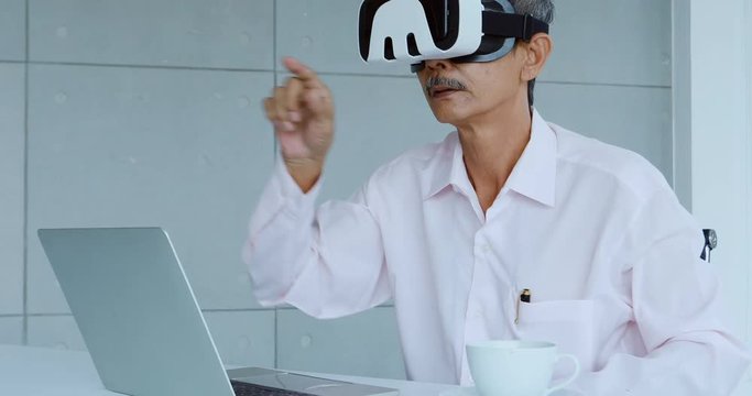 Senior businessman are viewing the contents of the virtual reality device, which is a technology of the future, Helps to make business easier and more successful.
