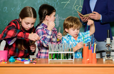 chemistry lab. back to school. happy children & teacher. kids in lab coat learning chemistry in school laboratory. making experiment in lab or chemical cabinet. Testing blood samples