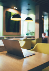 Open laptop on the table in city cafe interior