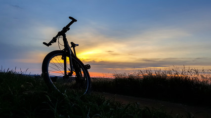 Fototapeta na wymiar Silhueta de bicicleta no entardecer com pôr-do-sol ao fundo