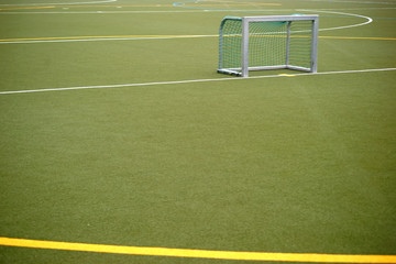 Die Nahaufnahme eines Kunstrasenplatzes für Fußballspiele und Feldhockey mit Farblinien und Farbmarkierungen.