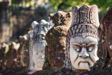 Reconstructed head sculptures, originally damaged by the Kyhmer Rouge, on the bridge leading to the south gate at Angkor Thom temple complex, Siem Reap, Cambodia