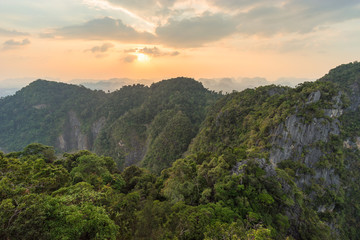 Jungle and mountains covered with tropical greenery and trees in Asian nature at sunset